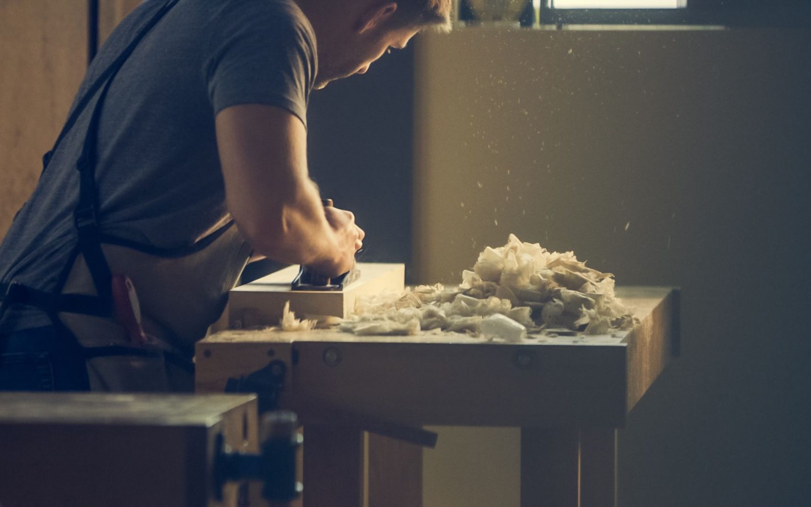 Handwerker schleift ein Holzwerkstück in der Werkstatt