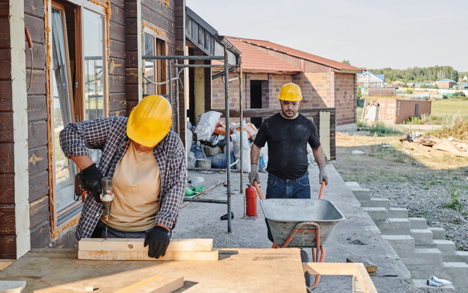 Zwei Handwerker in Arbeitskleidung besprechen sich auf der Baustelle